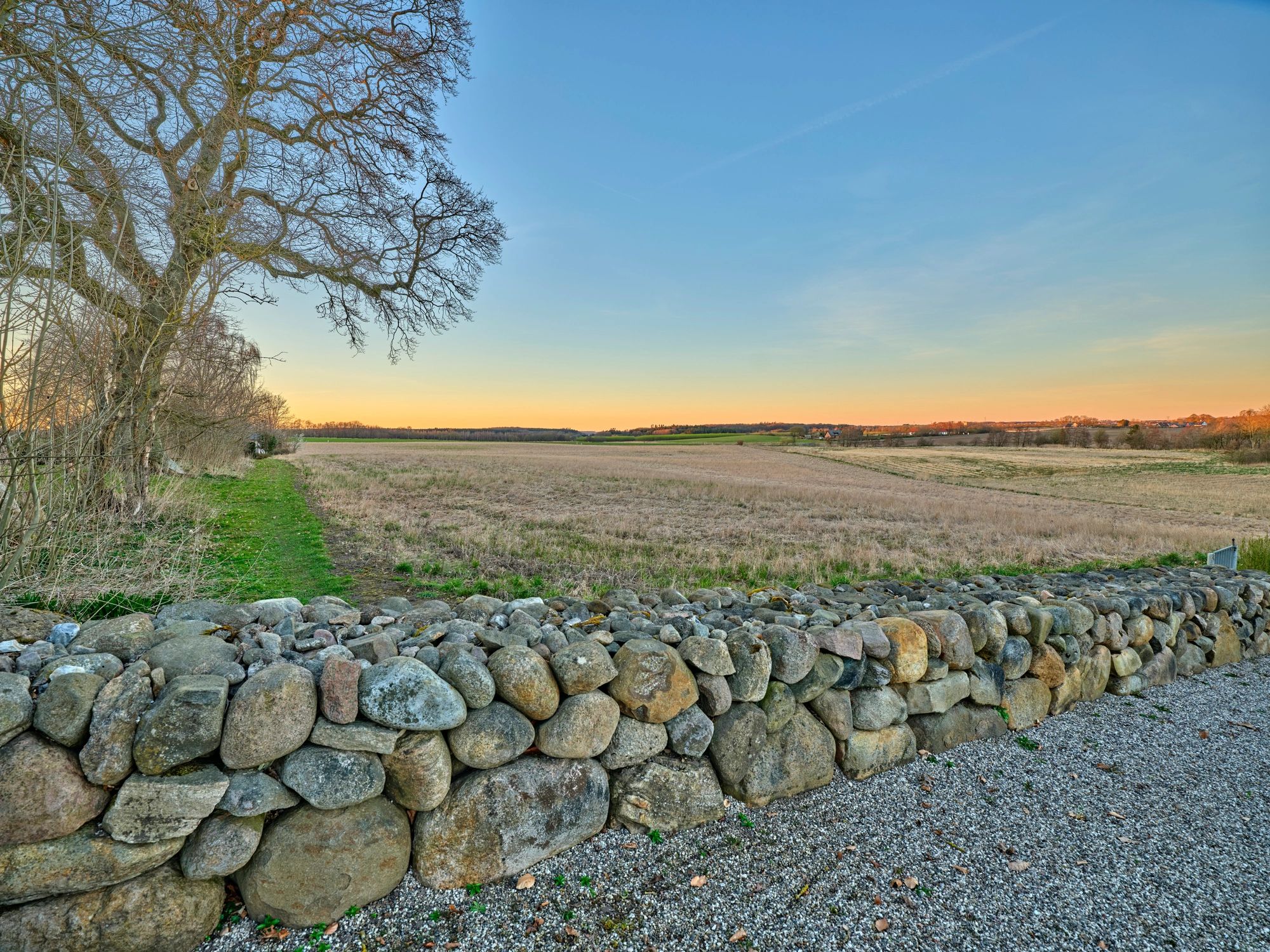 Stone wall running through an open landscaped setting